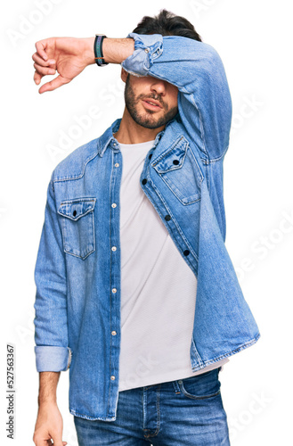 Young hispanic man wearing casual clothes covering eyes with arm, looking serious and sad. sightless, hiding and rejection concept © Krakenimages.com