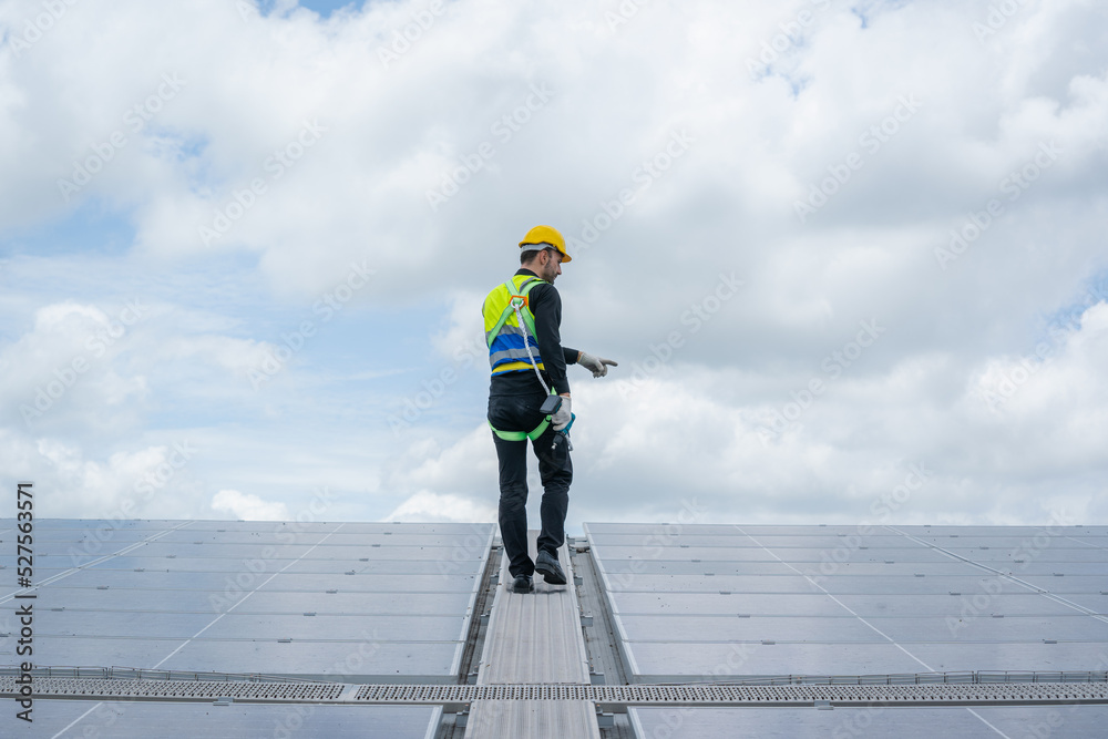 Engineer man or worker checking the operation of the system solar panels or solar cells on roof,Renewable energy source,Eco technology for electric power. Engineer man or worker checking the operation of the system solar panels or solar cells on roof,Renewable energy source,Eco technology for electric power.