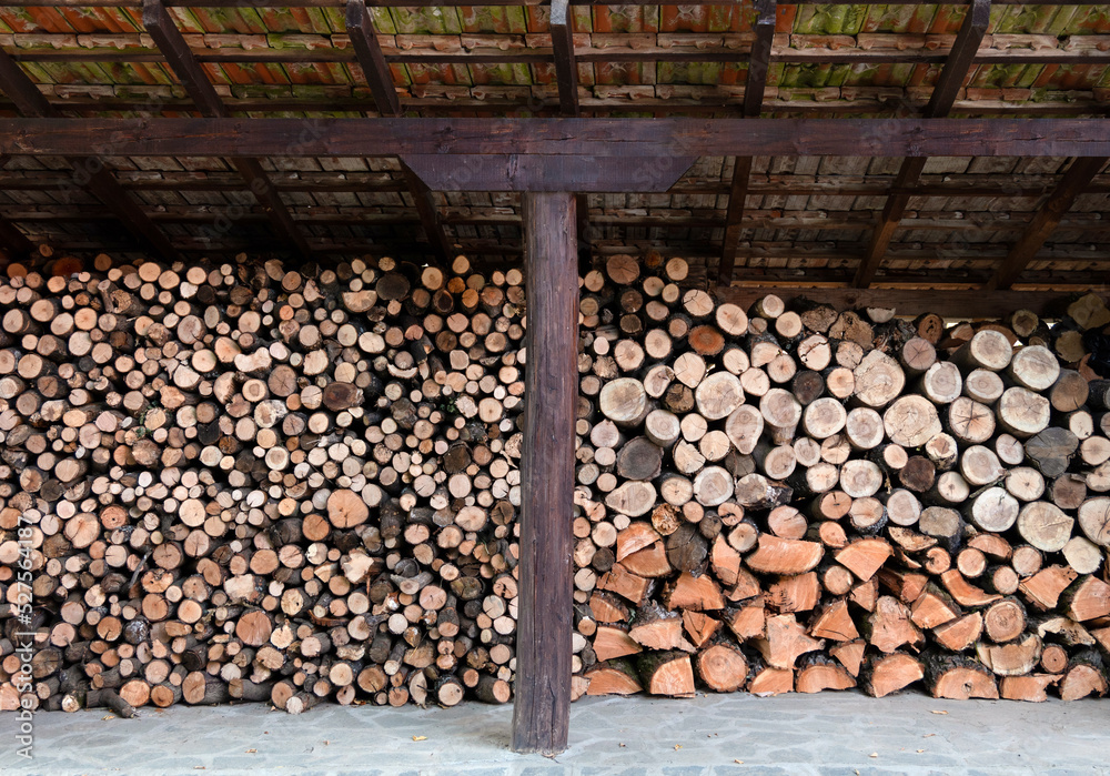 Chopped dry wood of different sizes and piled and stored undel roof for winter Chopped dry wood of different sizes and piled and stored undel roof for winter