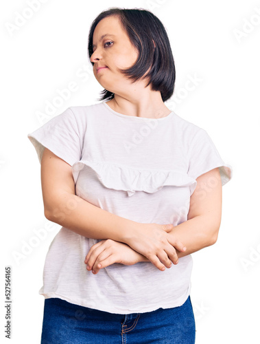 Brunette woman with down syndrome wearing casual white tshirt looking to the side with arms crossed convinced and confident © Krakenimages.com