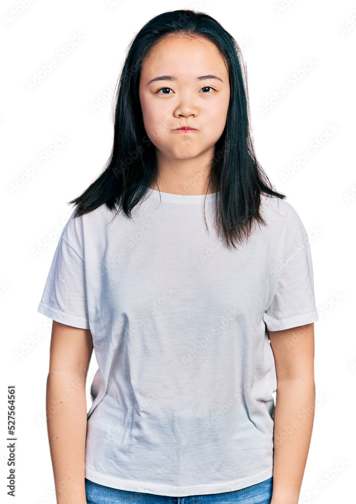 Young chinese woman wearing casual white t shirt puffing cheeks with funny face. mouth inflated with air, crazy expression. Young chinese woman wearing casual white t shirt puffing cheeks with funny face. mouth inflated with air, crazy expression.