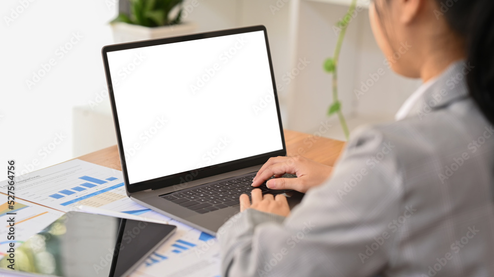 Professional businesswoman using laptop and working with document on office desk Professional businesswoman using laptop and working with document on office desk