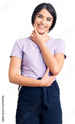 Brunette teenager girl wearing casual clothes looking confident at the camera smiling with crossed arms and hand raised on chin. thinking positive. © Krakenimages.com