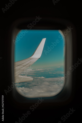 Airplane interior or jet window with clouds and sky