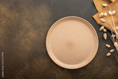 Canvas Print Table setting, empty plate and cutlery on a brown background, top view of the se