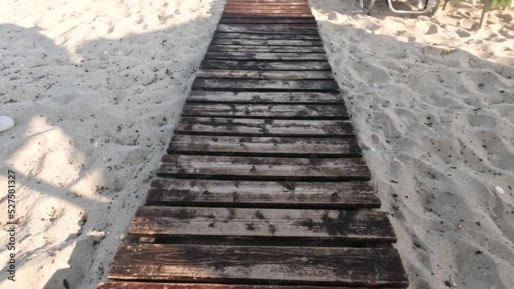 Walking on wooden boardwalk footpath over sandy beach. Summer holidays. Walking on wooden boardwalk footpath over sandy beach. Summer holidays.