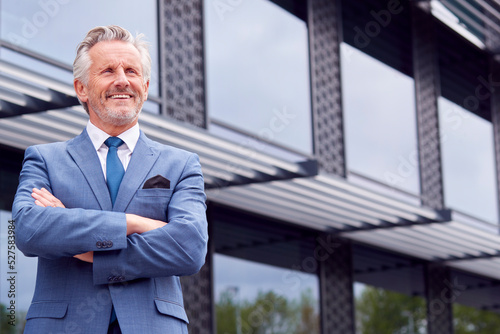 Portrait Of Smiling Senior Businessman CEO Chairman Standing Outside Modern Office Building