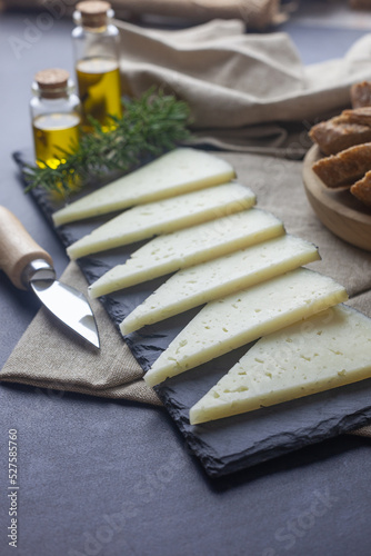 Lonchas de queso manchego sobre un plato rectangular de piedra