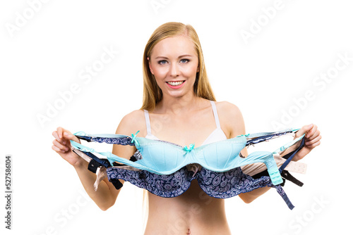 Woman holds bras, choosing photo