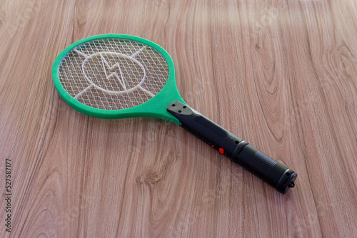 mosquito killing electric zapper racket green and white on wooden background isolated