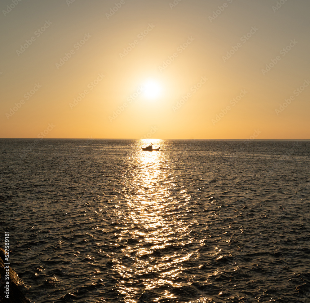 A ship at sunset on the horizon of the sea