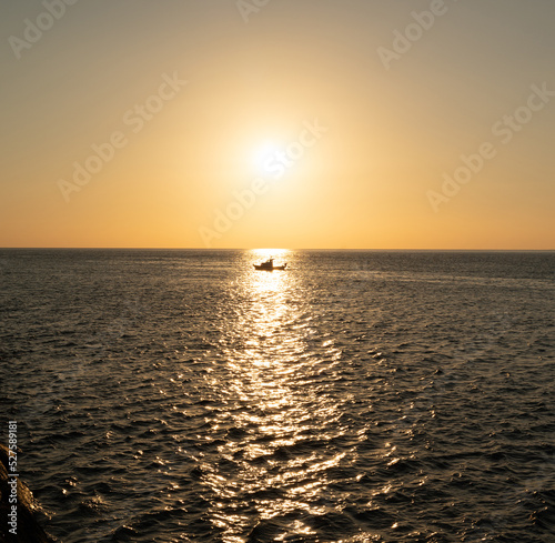 A ship at sunset on the horizon of the sea