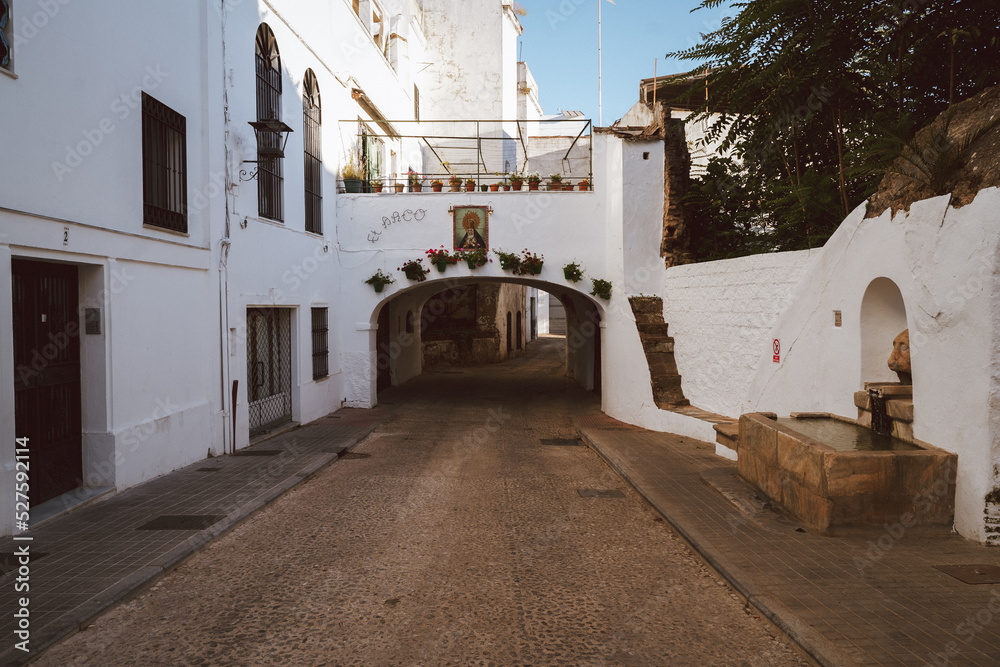 White houses with ancient arch with a virgin figure in Aracena (Huelva) in Andalusia (Spain)