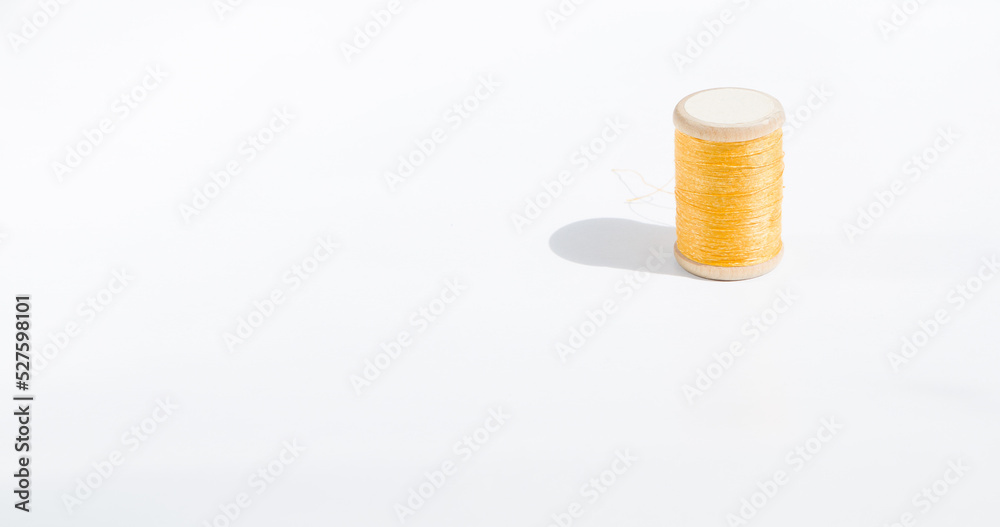 Spool of yellow threads on a white background vintage Spool of yellow threads on a white background vintage