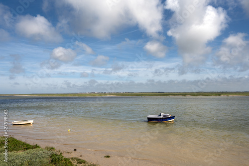 Little blue boat on the Bay of Somme on a cloudy spring afternoon, Hauts-de-France, France