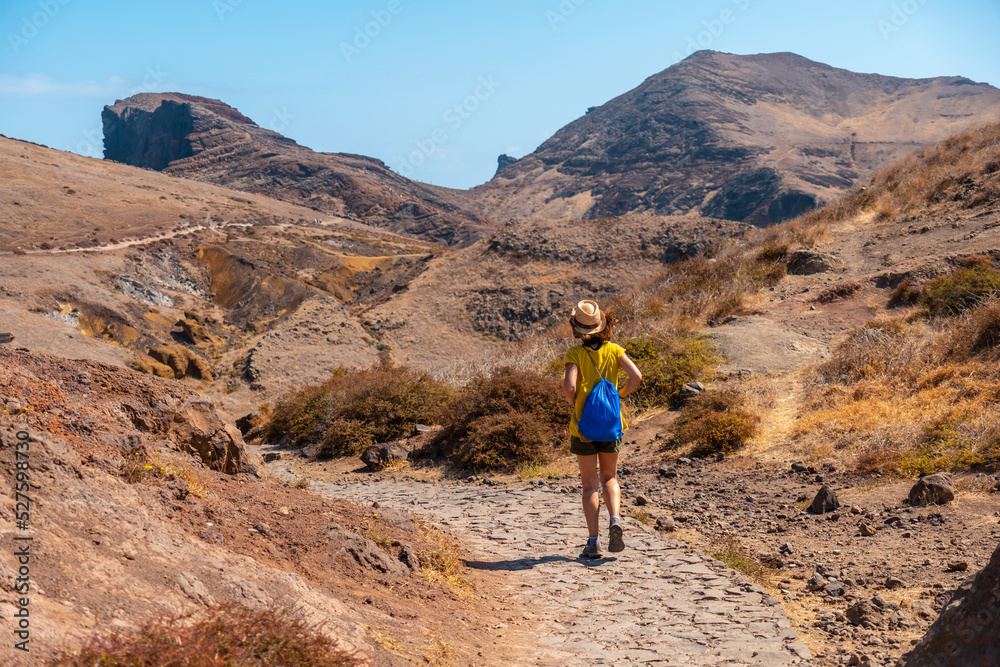 Young woman tourist on a trekking trail in Ponta de Sao Lourenco in summer, Madeira coast Young woman tourist on a trekking trail in Ponta de Sao Lourenco in summer, Madeira coast