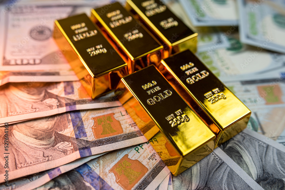 Gold ingots on American dollar banknotes close-up isolated on plain background. Gold ingots on American dollar banknotes close-up isolated on plain background.