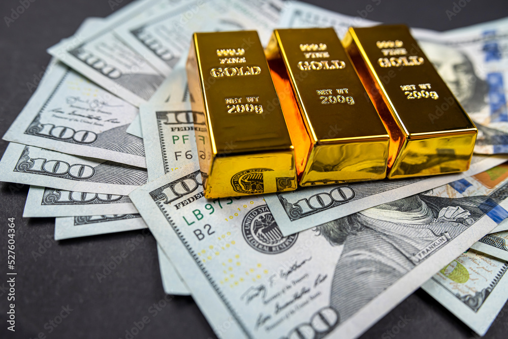  dollar banknote foreign currency and gold bullion prices isolated on dark background.