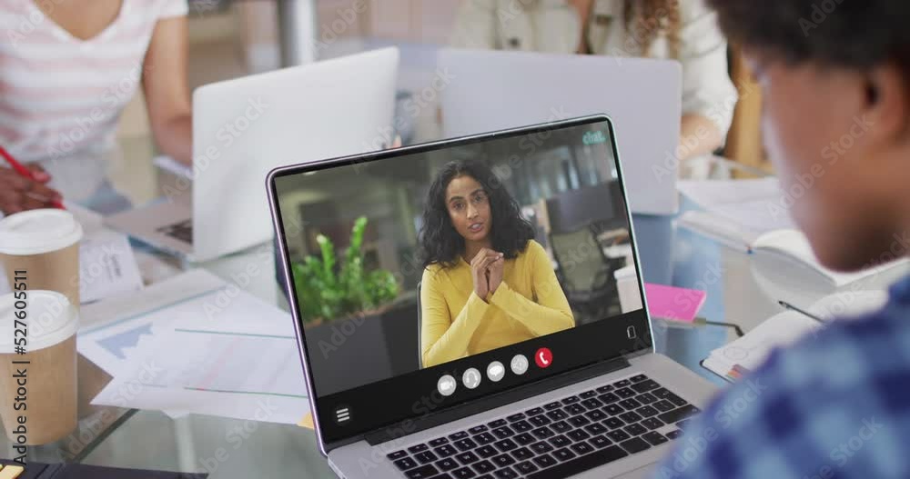 African american woman using laptop for video call, with business colleague on screen