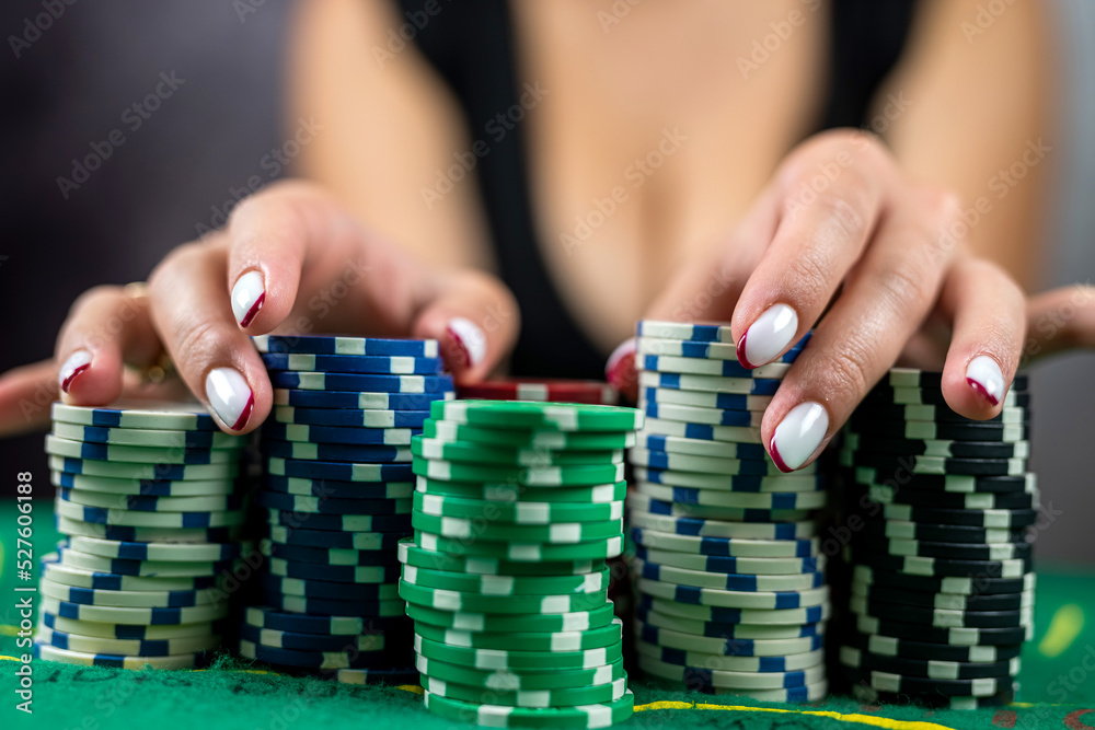 beautiful woman in an evening black dress plays poker in a casino for high stakes.