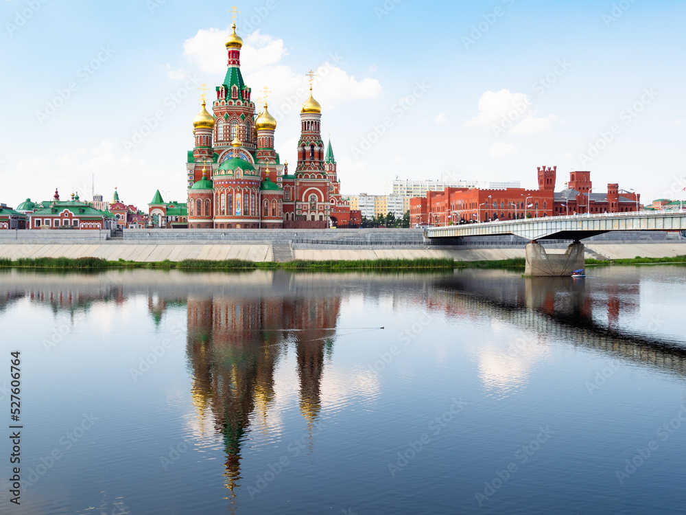 view of Cathedral of the Annunciation of the Blessed Virgin Mary near Theater bridge on Voskresenskaya embankment across Malaya Kokshaga river in Yoshkar-ola city on sunny summer day