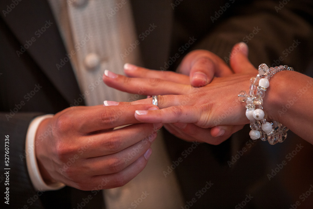 Close up of loving bride and groom putting a beautiful wedding ring to the beloved partner, marry me concept. High quality photo Close up of loving bride and groom putting a beautiful wedding ring to the beloved partner, marry me concept. High quality photo