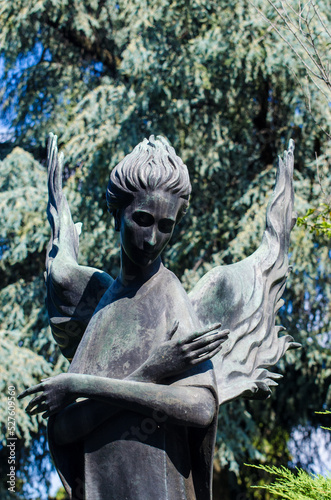La statua bronzea di un angelo su una tomba dell cimitero maggiore di Milano