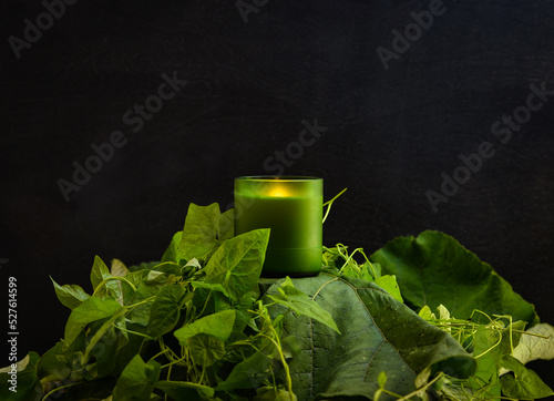 Photography object photo of a candle on a black background, the candle stands on a variety o