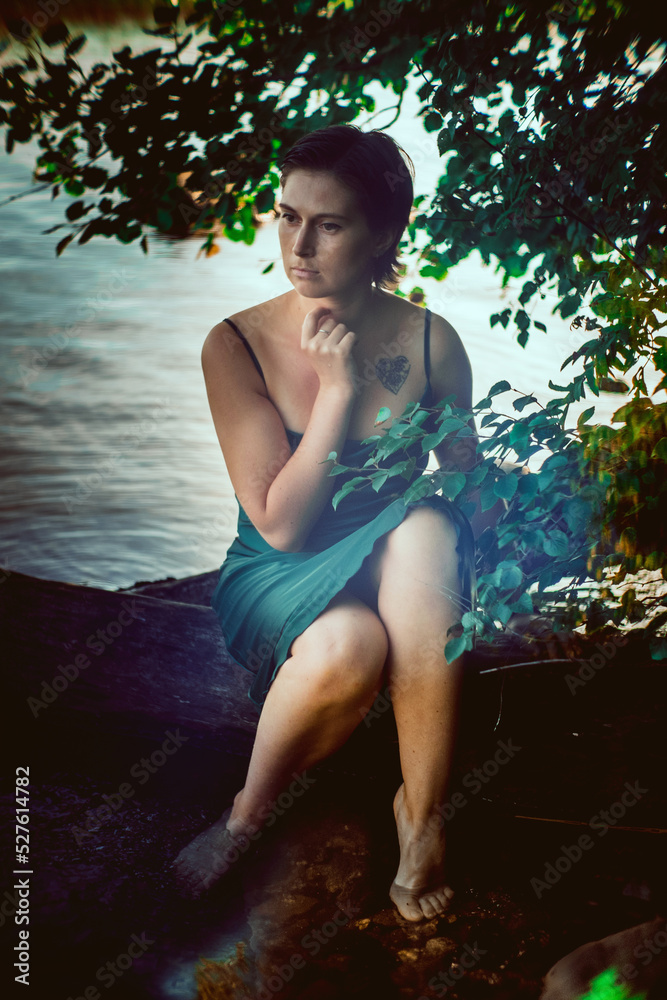 Fototapeta premium Beautiful young girl in an emerald dress in nature