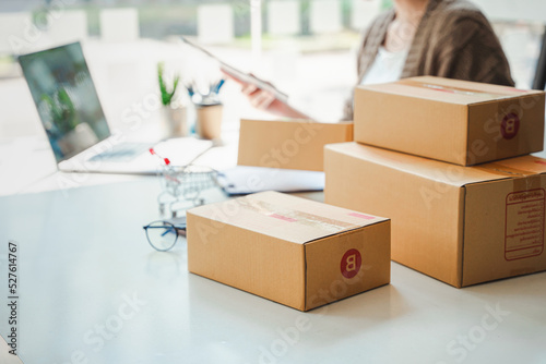 Portrait of a Small Business Startup, SME Owner, Female Entrepreneur work on parcel boxes Receipts and check orders online to prepare boxes. Selling to customers. Online SME business idea.