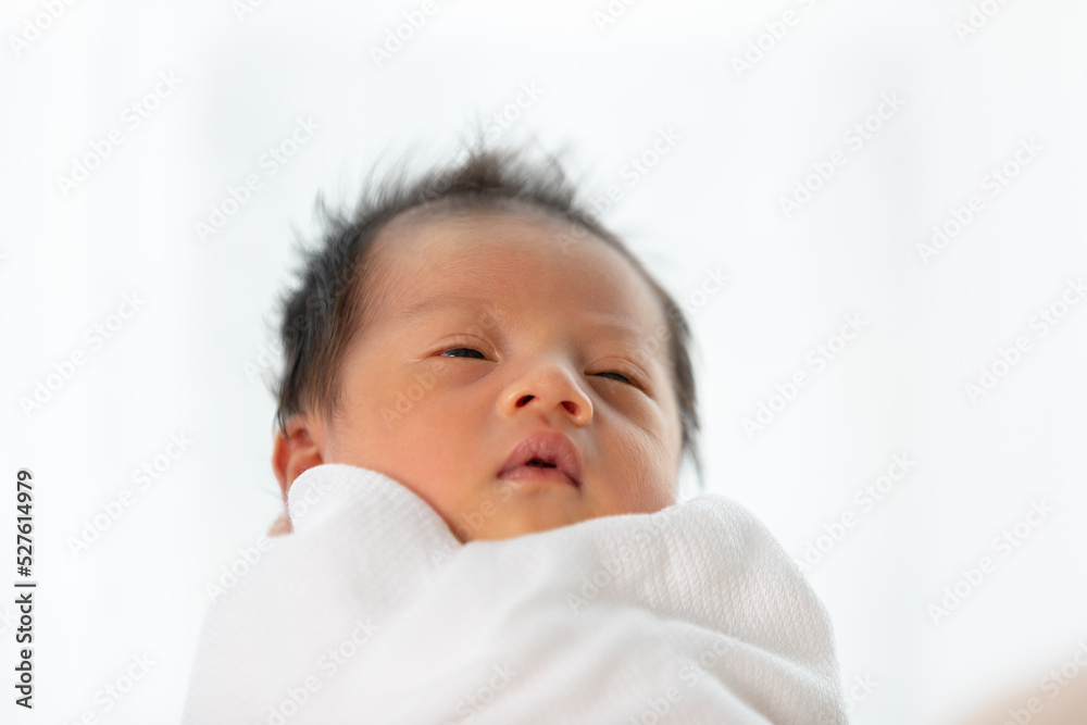 Asian newborn baby open eyes and looking around excited and happiness. Cute infant baby boylooking at mother with love. Good moment. Newborn Baby Care concept Asian newborn baby open eyes and looking around excited and happiness. Cute infant baby boylooking at mother with love. Good moment. Newborn Baby Care concept