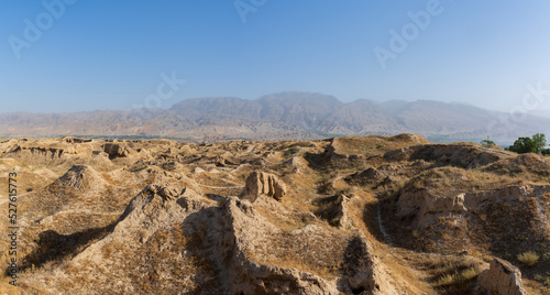 Landscape panorama of the Zeravshan river valley with ruins of ancient silk road sogdian city Penjikent in foreground, Panjakent, Sughd region, Tajikistan
