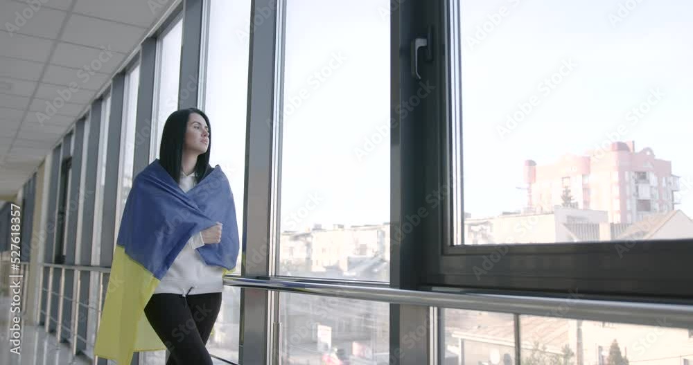 Young woman holding Ukrainian flag in the modern building Young woman holding Ukrainian flag in the modern building