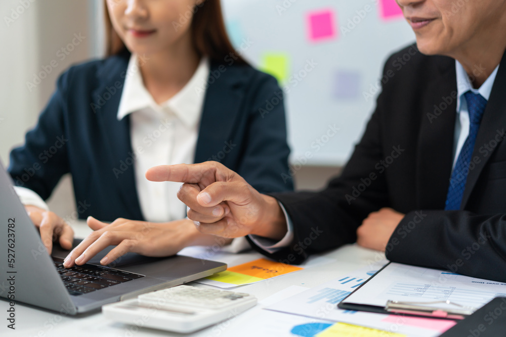 Business partnership concept, Businesswoman is typing on laptop while senior point and explain data Business partnership concept, Businesswoman is typing on laptop while senior point and explain data