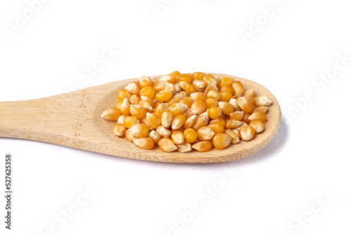 Dried corn or popcorn grains in a spoon isolated over white background