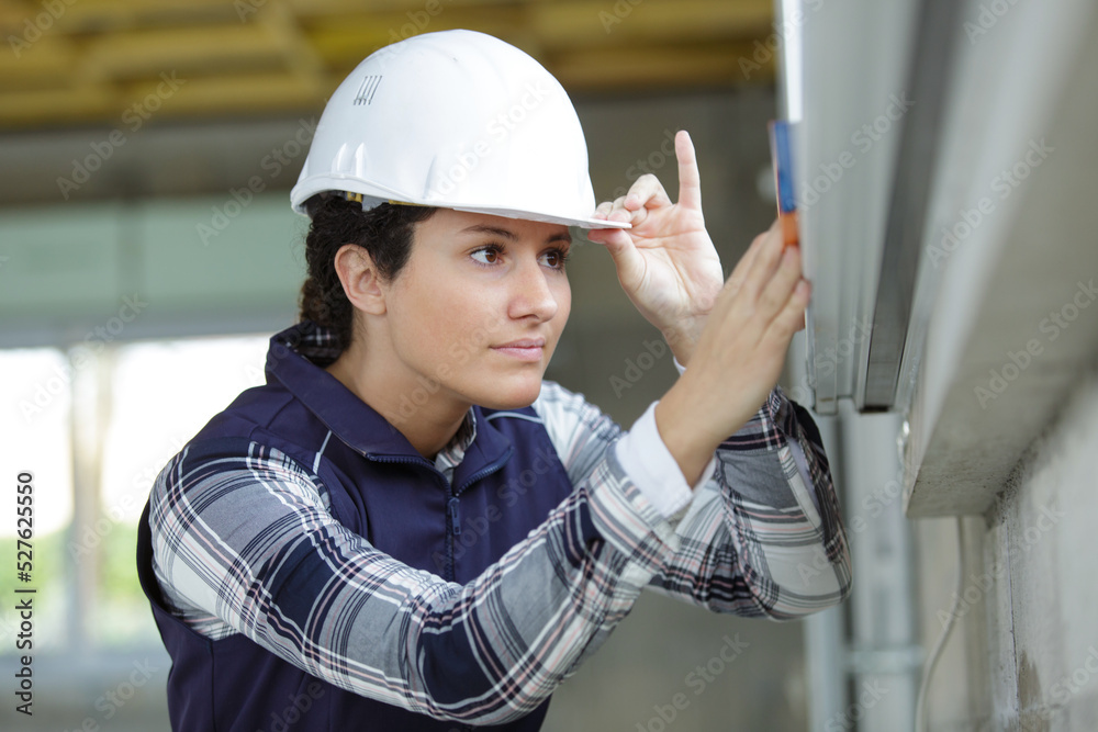 woman with measure level tool on construction site