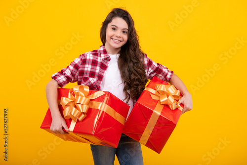 Happy teenager, positive and smiling emotions of teen girl. Child with gift present box on isolated studio background. Gifting for kids birthday.