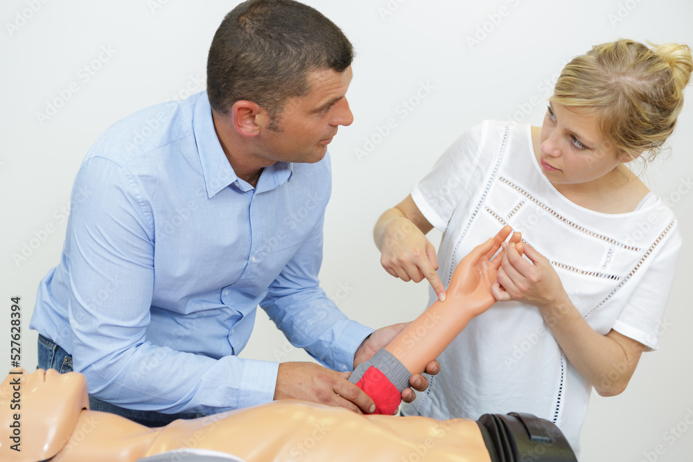 Fototapeta premium male instructor showing cpr training on dummy to his student