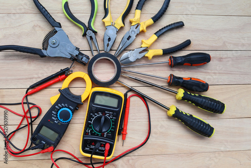 Electrical instruments, hardware tools for repair or maintenance, and installation of the electric system isolated on wooden background closeup.