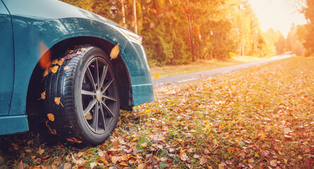Blue car on the autumnal asphalt road in countryside