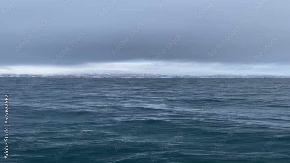 Portrait shot of the deep blue arctic ocean. Camera flying above the water. Winter ocean drone scene. Dark blue, ice-cold ocean in Norway. Social media post content. Dramatic cloudy sky seascape. Portrait shot of the deep blue arctic ocean. Camera flying above the water. Winter ocean drone scene. Dark blue, ice-cold ocean in Norway. Social media post content. Dramatic cloudy sky seascape.