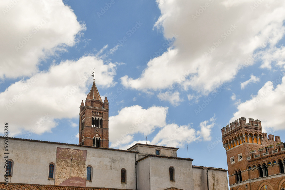 High-section of the Cathedral of St Lawrence and of Palazzo Aldobrandeschi with the towers against a cloudy sky, Grosseto, Tuscany, Italy
