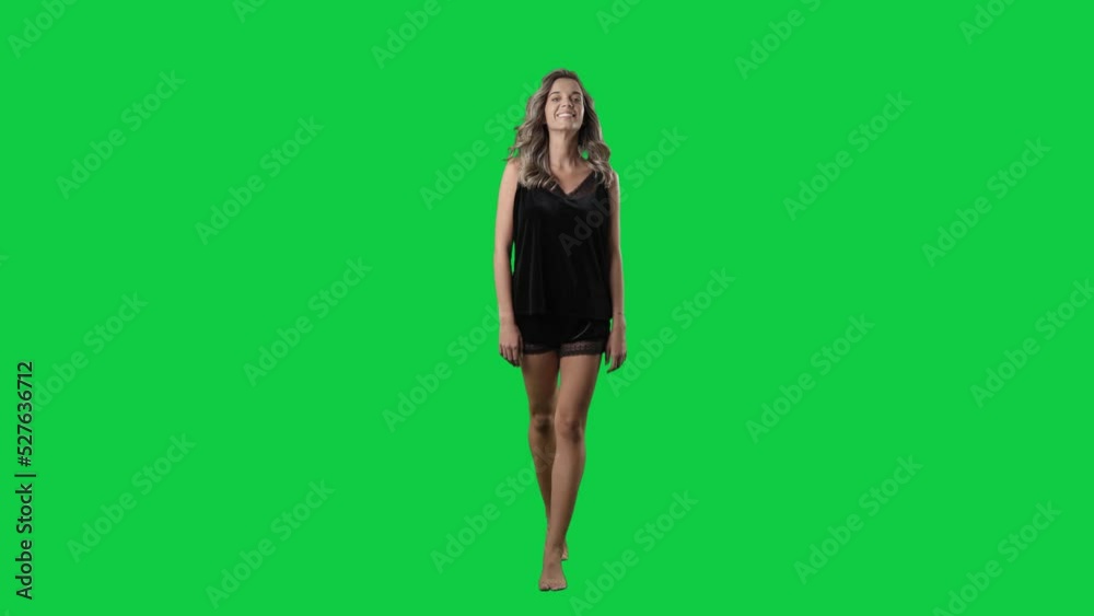 Young beauty woman in black satin pajama walking in slow motion. Full body isolated on green screen background Young beauty woman in black satin pajama walking in slow motion. Full body isolated on green screen background