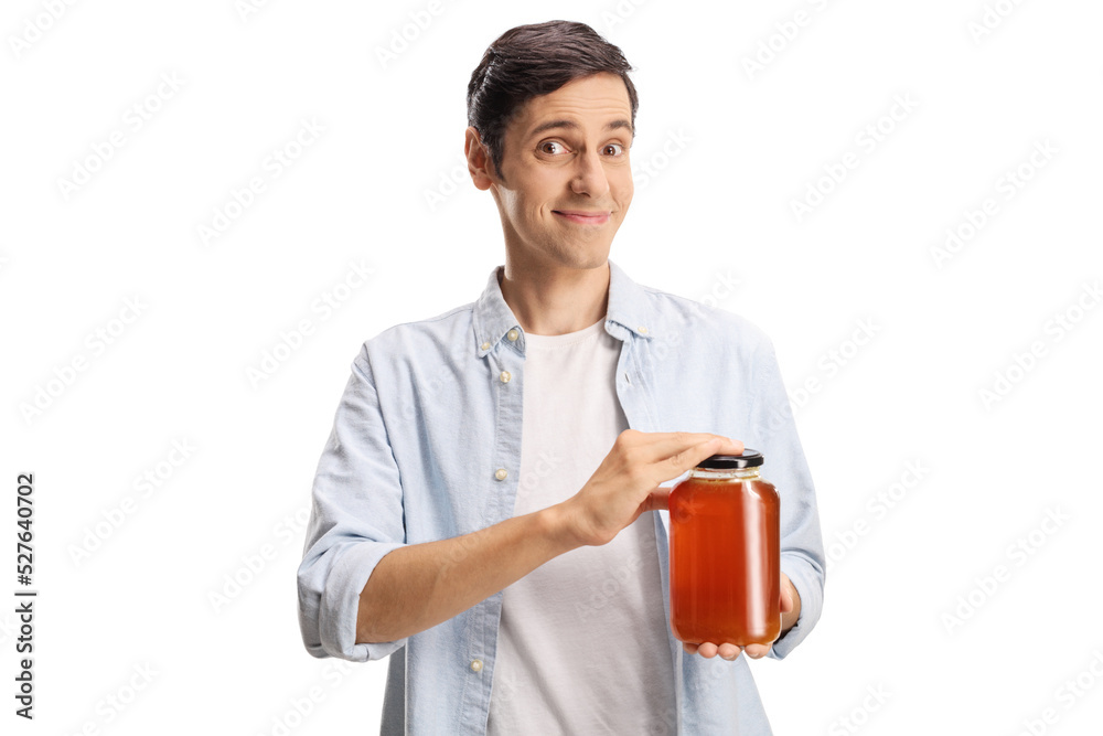 Young man holding a jar of honey and smiling Young man holding a jar of honey and smiling