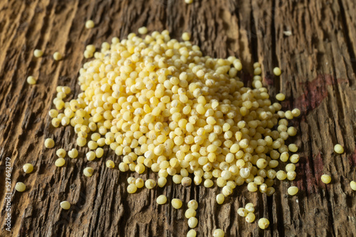 Grits millet on a wooden board close-up