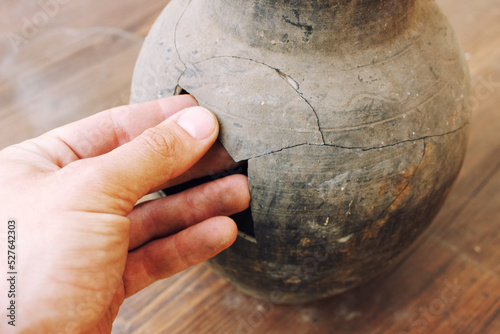 Man hand restoration broken fragments earthenware jug photo