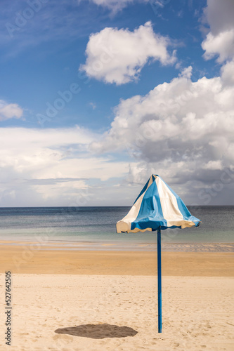 an umbrella on the beach of the tropical island. Vacation relaxation with turquoise sea and blue sky landscape. Summer vacation travel concept
