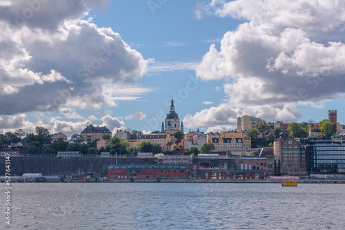 View over the district Södermalm with church, towers and harbor a sunny day with cumulus clouds in Stockholm