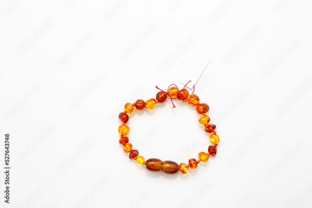 Amber bracelet on a white background. Place for an inscription on the product label. Jewelry for women. semi-precious mineral. Copal. Fossil fossilized resin. Crystal. Decorations Amber bracelet on a white background. Place for an inscription on the product label. Jewelry for women. semi-precious mineral. Copal. Fossil fossilized resin. Crystal. Decorations