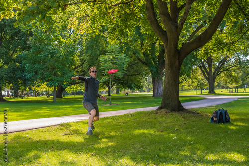 Disc golf, a flying disc sport played using rules like golf, being played by a middle aged man on a nine hole course in Ashbridges Bay Park in Toronto’s Beaches neighbourhood in late August.